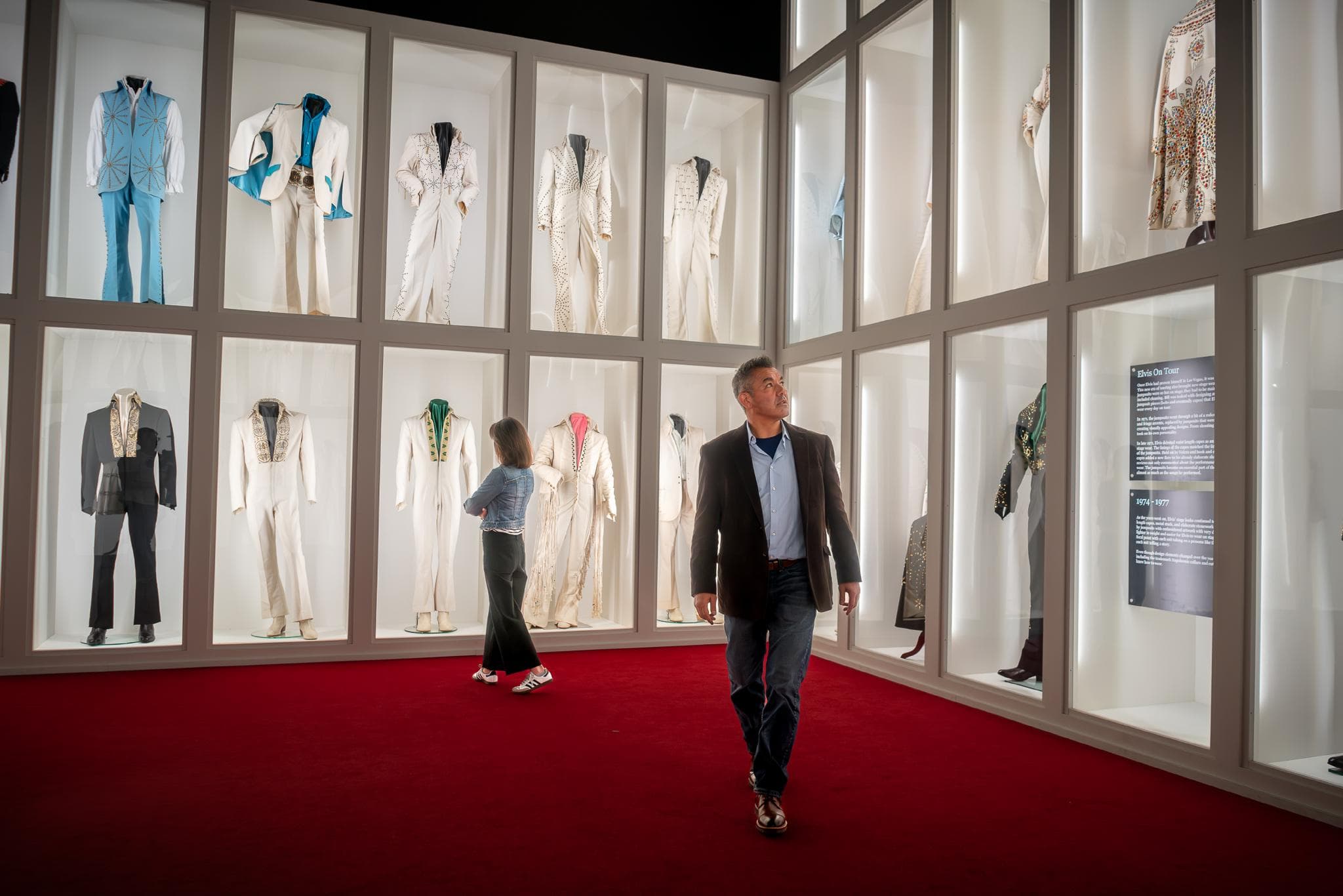 A couple enjoying Elvis' jumpsuit and stage costume collection at Elvis Presley's Graceland.